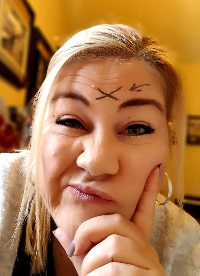 a woman with scrunched up face and x on her forehead